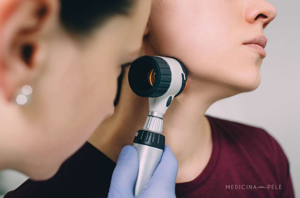 Profissional examina a pele do pescoço de paciente com dermatoscópio durante consulta dermatológica.
