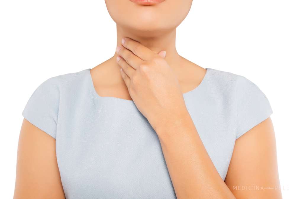 Fotografia mostra uma mulher tocando a região frontal do pescoço com expressão neutra, sugerindo desconforto ou dor na garganta, possivelmente relacionada a condições como linfoma cutâneo ou inflamação cervical.