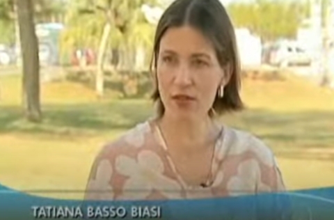 Mulher de blusa estampada fala em entrevista ao ar livre, com legenda identificando seu nome como Tatiana Basso Biasi.