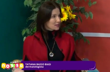 Fotografia de estúdio, mulher de blazer vermelho com girassóis ao fundo.